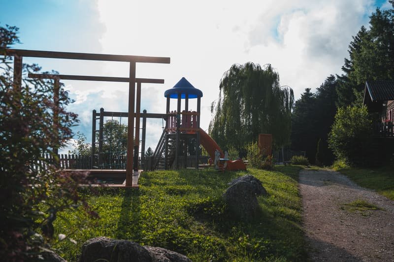 Spielplatz mit Kletterturm und Rutsche neben dem Gasthaus