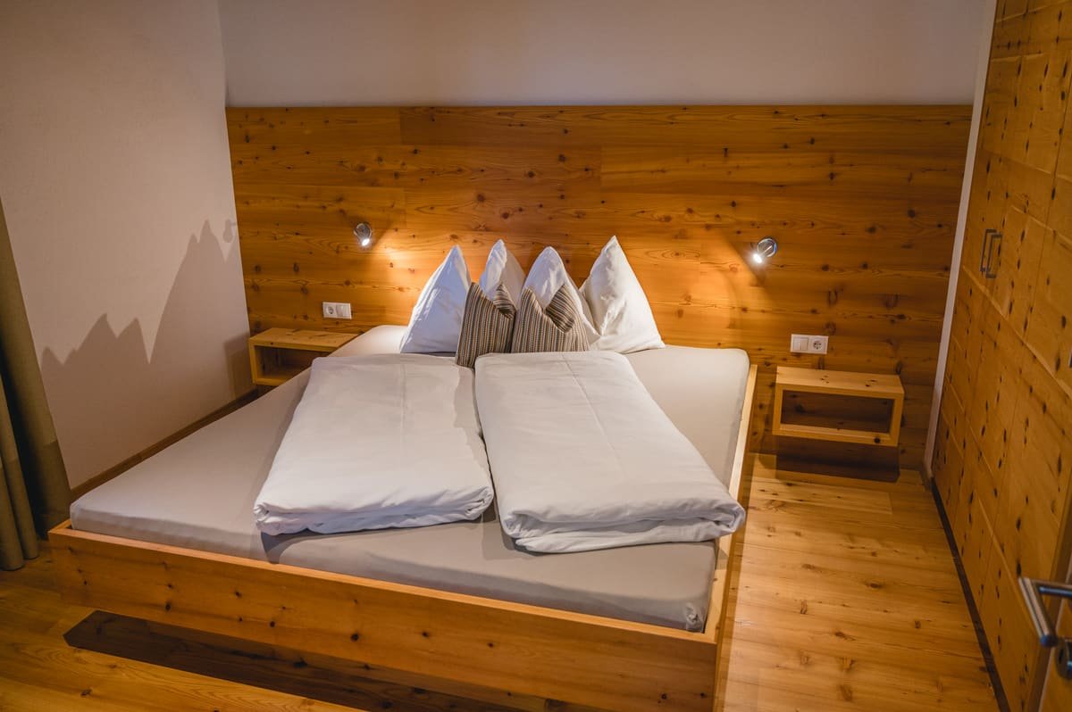 Zimmer 1 mit Doppelbett, Holzkopfteil und zwei Nachttischen
