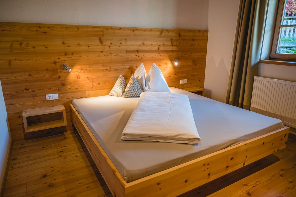 Zimmer 2 mit Doppelbett, Holzboden und Fenster
